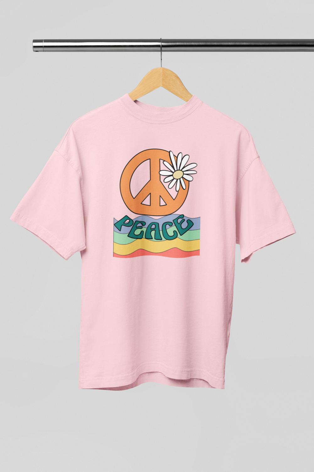 Pink t-shirt with peace symbol and 'PEACE' text on a hanger by ZealforTee